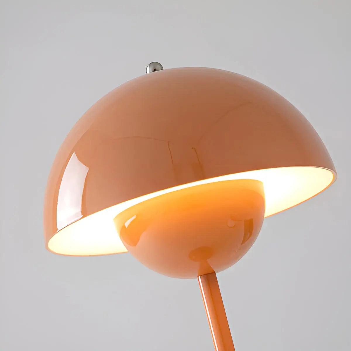Orange lamp with a dome-shaped shade on a gray background