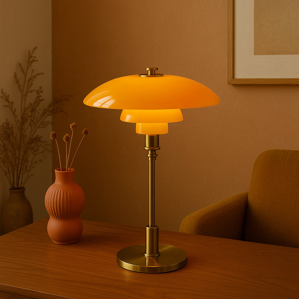 Table lamp with orange glass shade on a wooden surface, with a warm-toned wall and decor in the background.