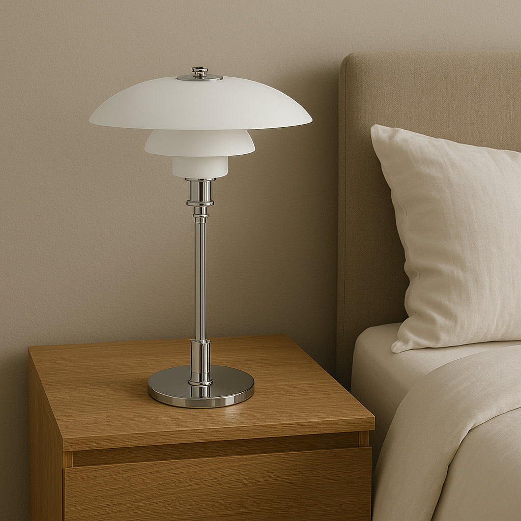 Table lamp on a wooden nightstand next to a bed with beige headboard and pillow.