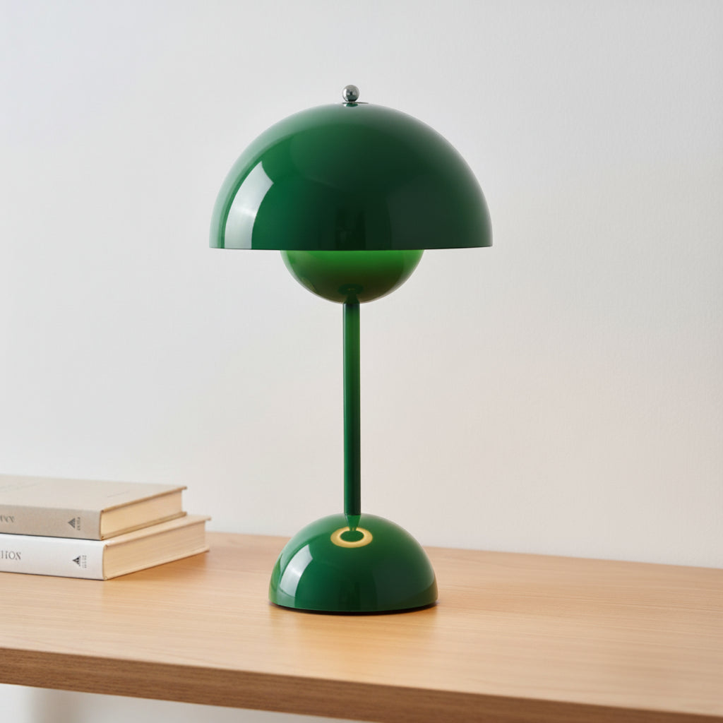 Green table lamp on a wooden surface with a light gray background